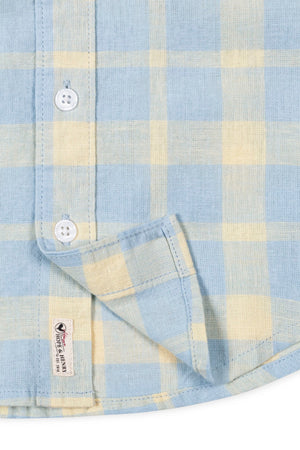 Close-up of a Hope & Henry boys linen shirt in sunlit plaid, featuring buttons and a brand tag.