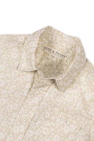 Close-up of a sandy floral short sleeve shirt by Hope & Henry, featuring a button front and chest pocket.
