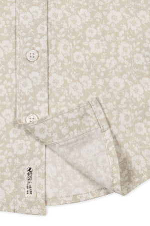 Close-up of a sandy floral short sleeve shirt by Hope & Henry, featuring a button front and breathable linen fabric.