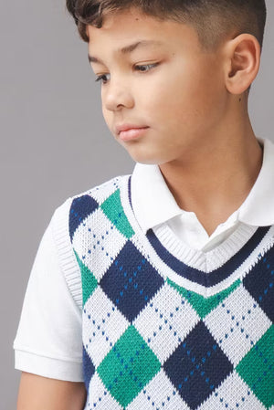 A boy models a white and green argyle sweater vest made from soft organic cotton, featuring a v-neckline and ribbed trim, paired with a classic white collared shirt.