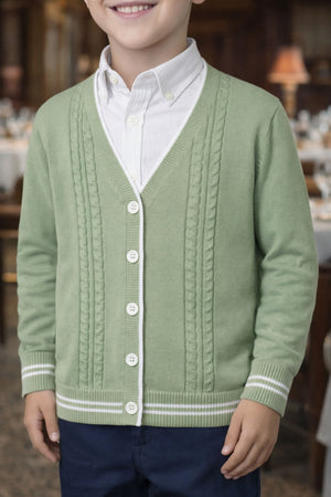 A boy wearing a soft green cable knit cardigan over a white shirt, featuring faux horn buttons and striped rib.