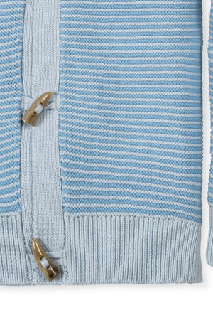 Close-up of a light blue striped cardigan featuring a shawl collar and toggle closure, made from soft organic cotton.