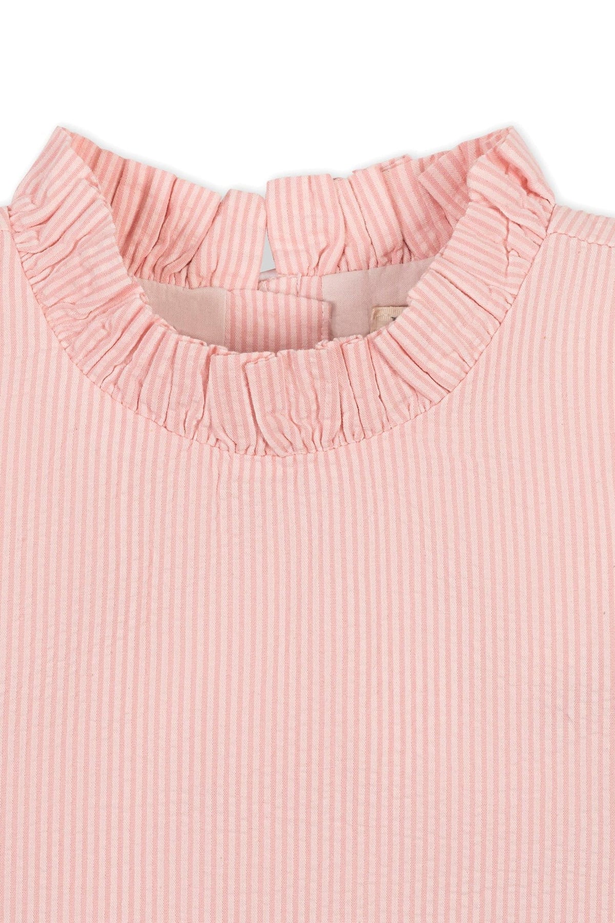 Close-up of a pink seersucker top with a ruffled collar, showcasing soft, organic cotton fabric and subtle striped pattern.