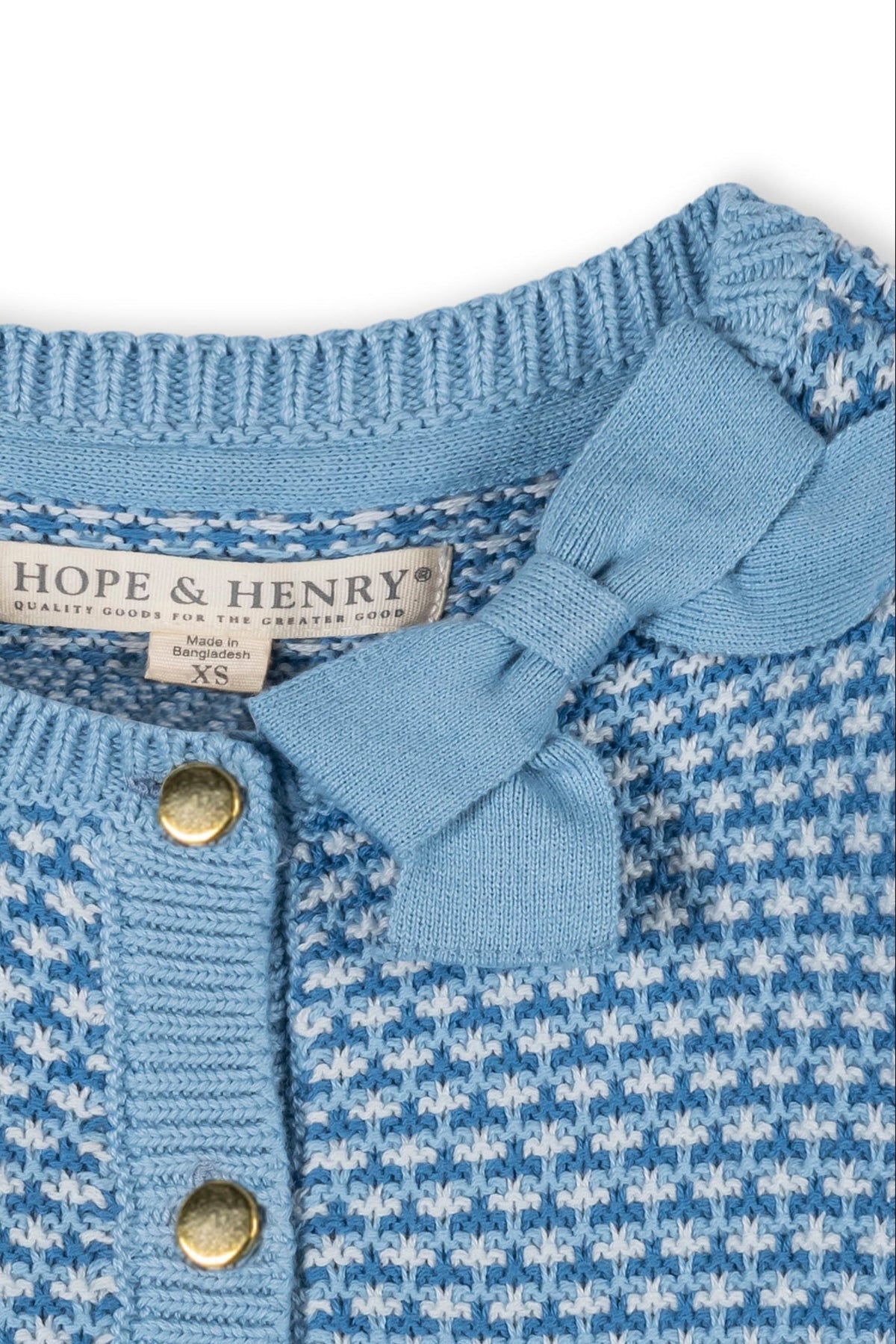 Close-up of a blue tweed stitch cardigan by Hope & Henry, featuring a bow detail at the collar and gold button closure.