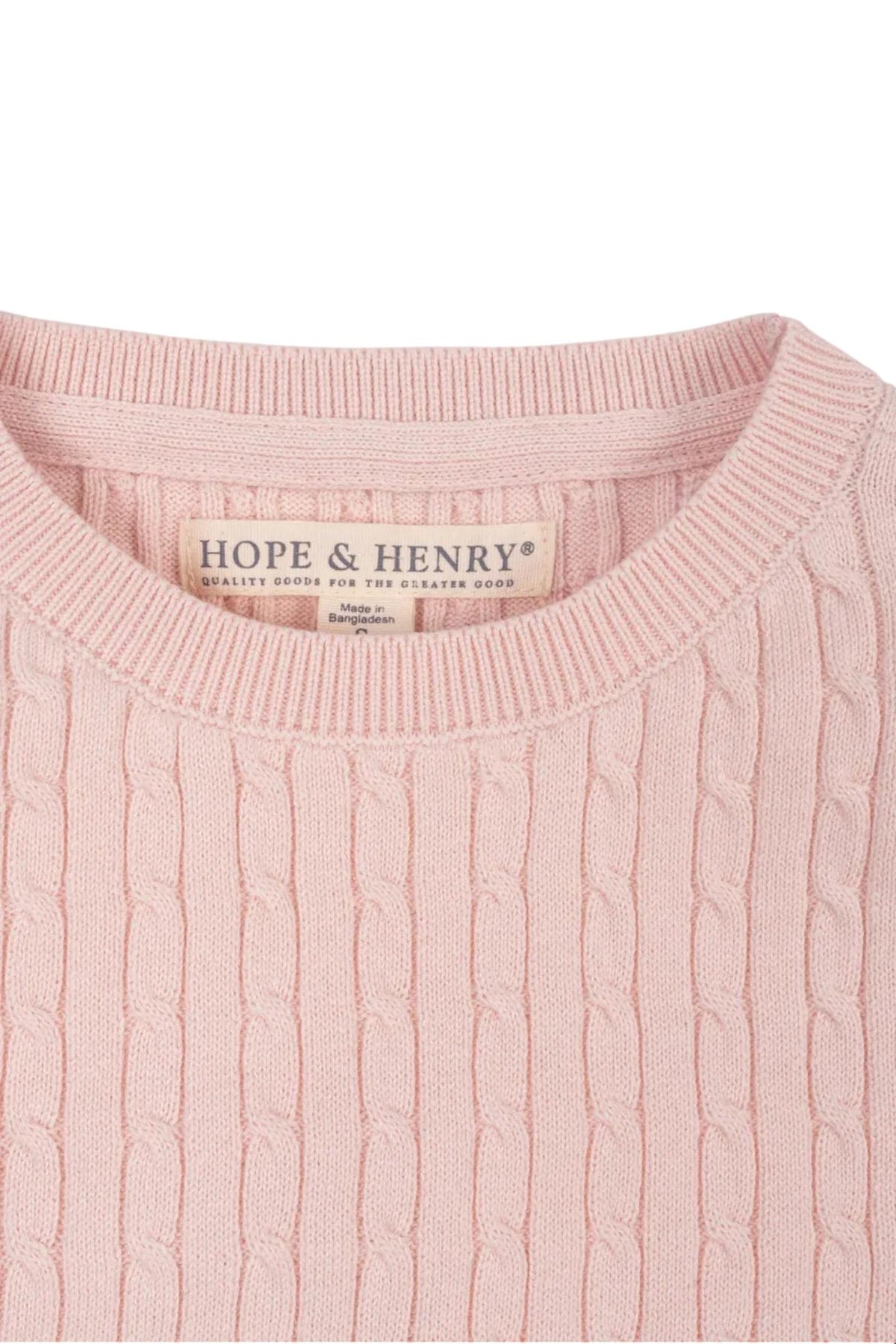 Close-up of a light pink short sleeve cable sweater by Hope & Henry, made from 100% organic cotton. The textured knit pattern is visible, showcasing its soft and sustainable material.