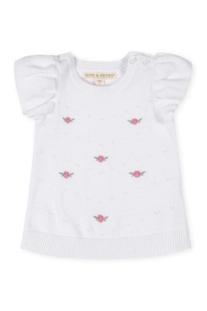 White pointelle sweater from Hope & Henry featuring ruffle sleeves and pink embroidered roses, made from 100% organic cotton.