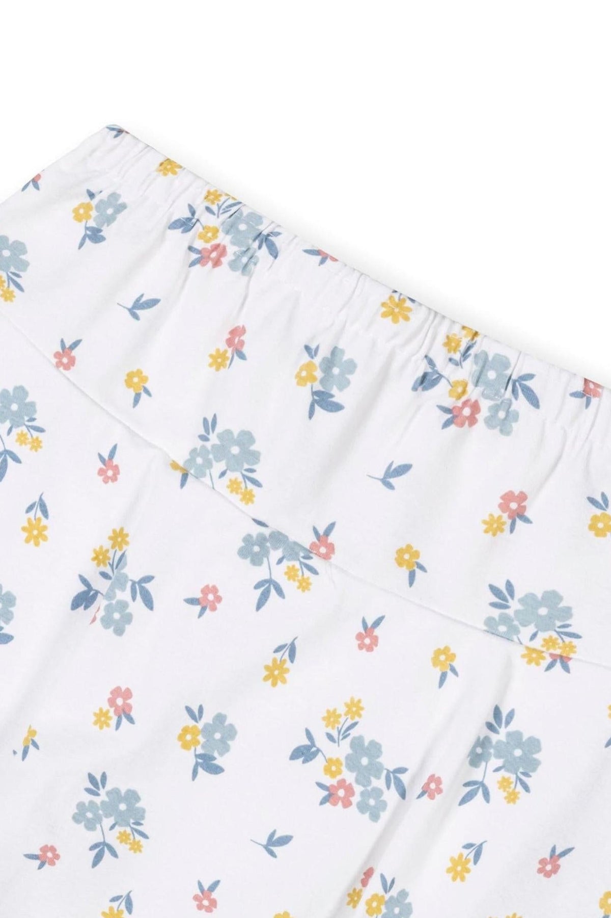 Close-up of a white skort featuring a colorful floral print in soft blue, yellow, and pink hues. Made from organic cotton, it has an elastic waistband for comfort and ease.