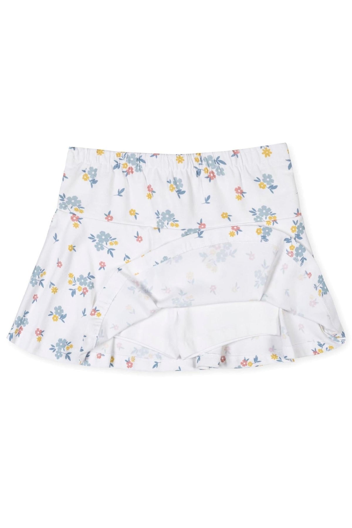 A flouncy skort in soft organic cotton features a white base adorned with colorful floral prints. The design includes an elastic back waist and a jersey inner short for comfort.