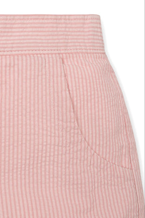 Close-up of pink seersucker fabric showcasing a pocket and textured stripes, ideal for girls organic cotton shorts.