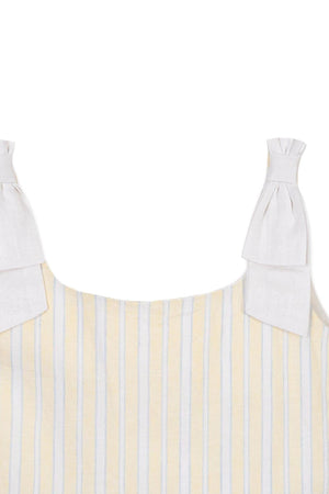 Close-up of a yellow and white striped dress featuring bow shoulder straps made of linen fabric, perfect for warm weather.