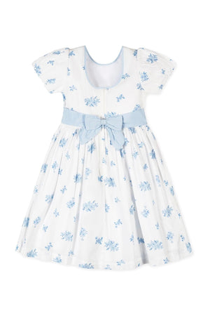 White organic cotton dress featuring delicate blue floral patterns, puff sleeves, and a matching bow at the waist.