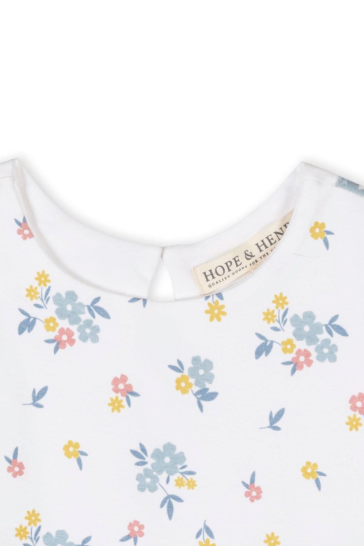 Close-up of a white tank dress featuring a colorful floral print, with a small keyhole opening at the back.