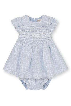 Light blue smocked baby dress with puff sleeves and matching diaper cover, featuring a subtle white floral pattern.