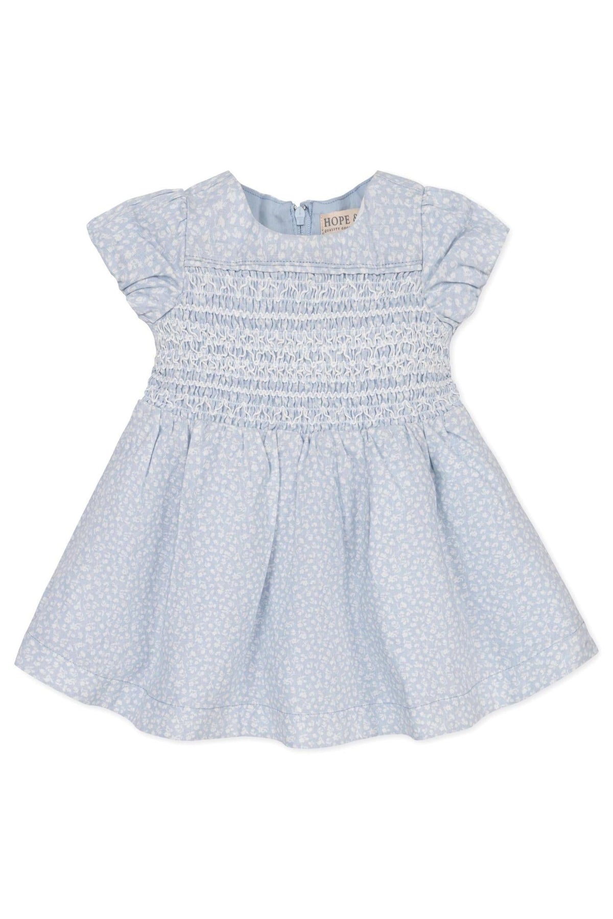 Light blue baby dress with smocked bodice and puff sleeves, featuring a subtle floral pattern. Made from linen blend.