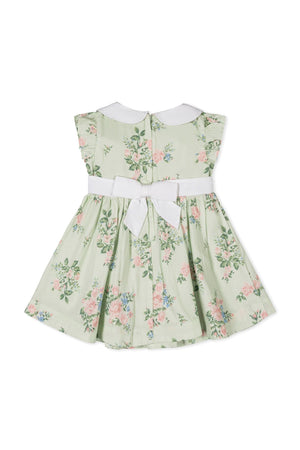 Back view of a light green floral dress with a white Peter Pan collar and a bow at the waist,.