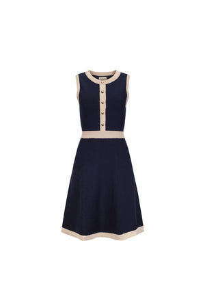 A sleeveless navy sweater dress features a button front, contrasting beige trims, and a flared skirt. Made from soft organic cotton, it combines style and comfort for year-round wear.