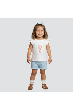 A smiling child wearing a white sleeveless top with a lobster graphic and blue shorts stands against a neutral background.