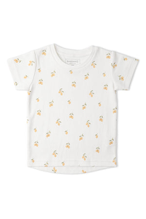 White organic cotton tee featuring a playful lemon print, perfect for warm days. Ideal for childrens casual wear, this soft shirt combines style and comfort for everyday play.