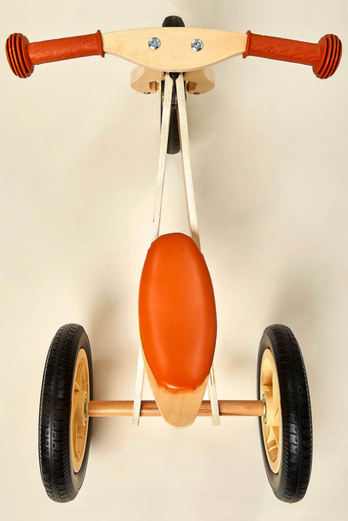 A top view of a 2-in-1 Midi Wooden Balance Bike featuring a natural wood frame, orange seat, and rubber tires.