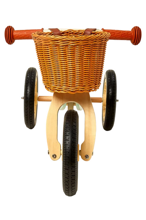 A wooden tricycle features a woven bike basket in warm tones, complemented by orange handlebars. The sustainable design highlights eco-friendly materials, perfect for young explorers.
