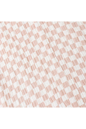 Lightweight brick check fabric in soft peach and white hues, perfect for a summer shirt and shorts set. Made from organic materials, ensuring comfort and sustainability for children.
