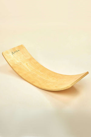 AIDA balance board in natural wood features a smooth, curved design. This sustainable play accessory encourages imaginative movement and is ideal for children to enhance balance and coordination.