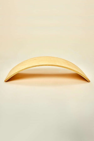 A natural wood balance board features a smooth, curved design, ideal for imaginative play and physical activity. Its sustainable construction promotes balance and coordination for children of various ages.