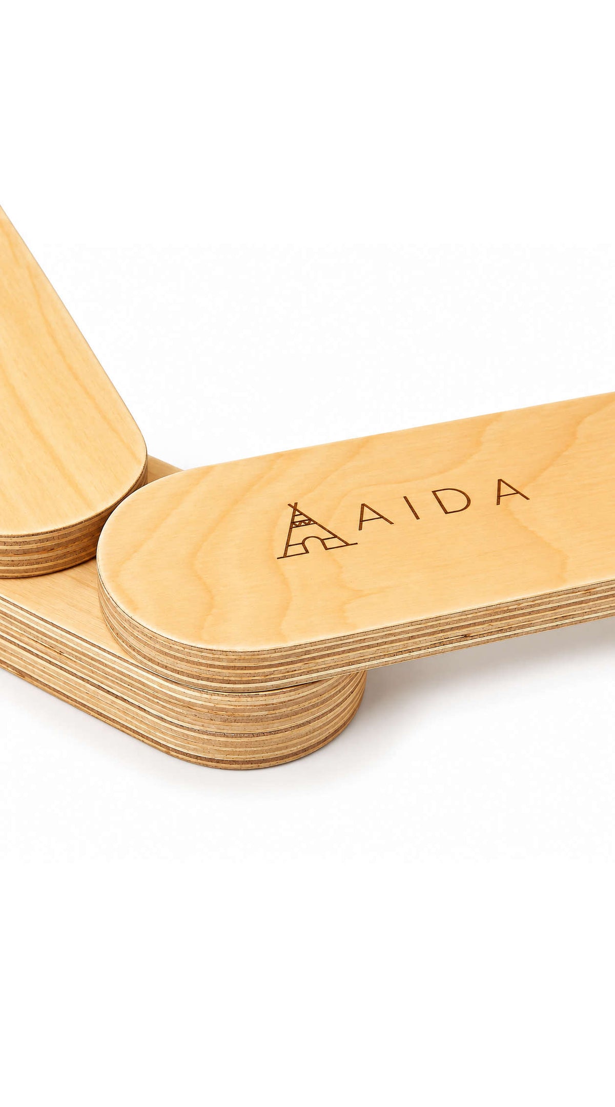Close-up of smooth, natural wood balance beams featuring the engraved brand name AIDA. The beams are designed for childrens active play and are made from sustainable materials.