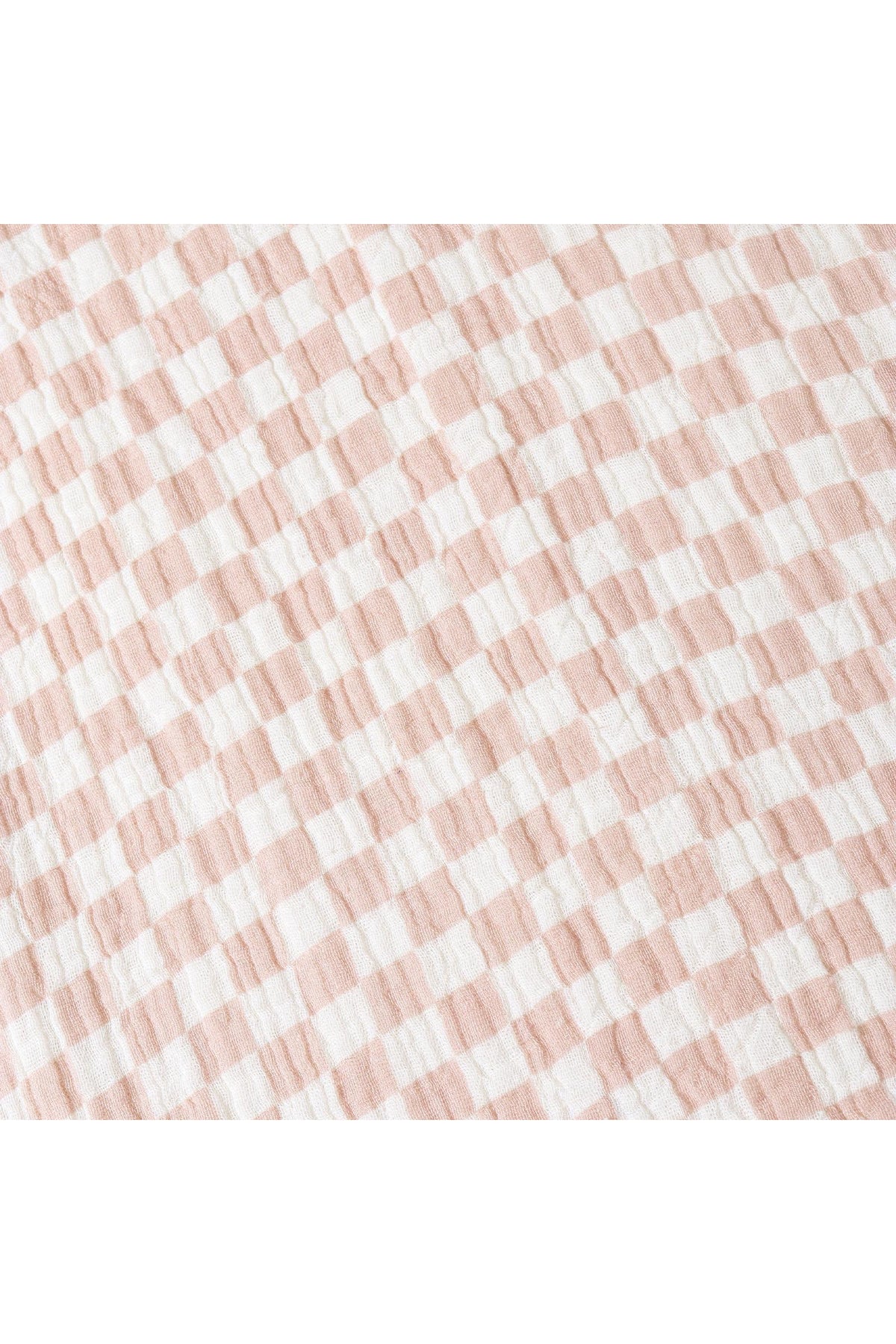 Close-up of a soft muslin cotton fabric featuring a brick check pattern in light pink and white. The texture is breathable and perfect for comfortable, sustainable clothing.