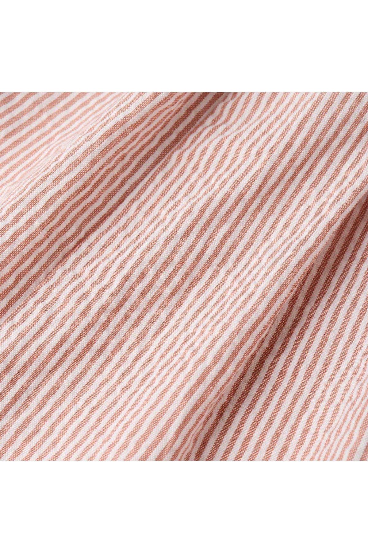 Close-up of coral striped fabric featuring delicate white lines, showcasing a soft, organic cotton texture ideal for childrens clothing. Perfect for stylish and comfortable playtime outfits.