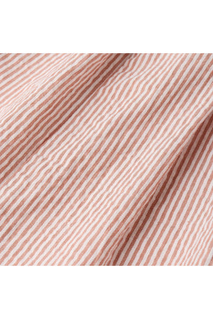 Close-up of coral striped fabric featuring delicate white lines, showcasing a soft, organic cotton texture ideal for childrens clothing. Perfect for stylish and comfortable playtime outfits.