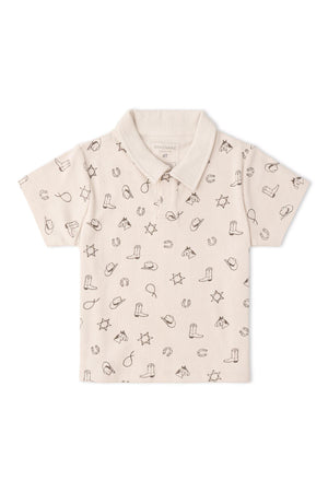 Light beige polo shirt featuring a whimsical rodeo print with boots, hats, and stars. Made from soft organic cotton, this shirt is perfect for comfortable, eco-friendly playtime.