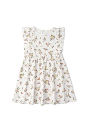 A sleeveless organic cotton dress featuring a white background adorned with colorful floral patterns. The dress has playful ruffled sleeves, making it a charming addition to any baby girls wardrobe.