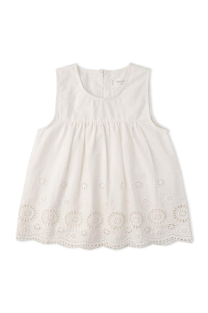 A white sleeveless top featuring intricate eyelet embroidery along the hem. Made from organic cotton, this delicate piece is perfect for warm-weather outings and celebrations.