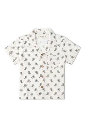 Lightweight, short-sleeve shirt featuring a cream background with a floral print in green and brown. Made from organic cotton, its perfect for keeping kids cool in summer.