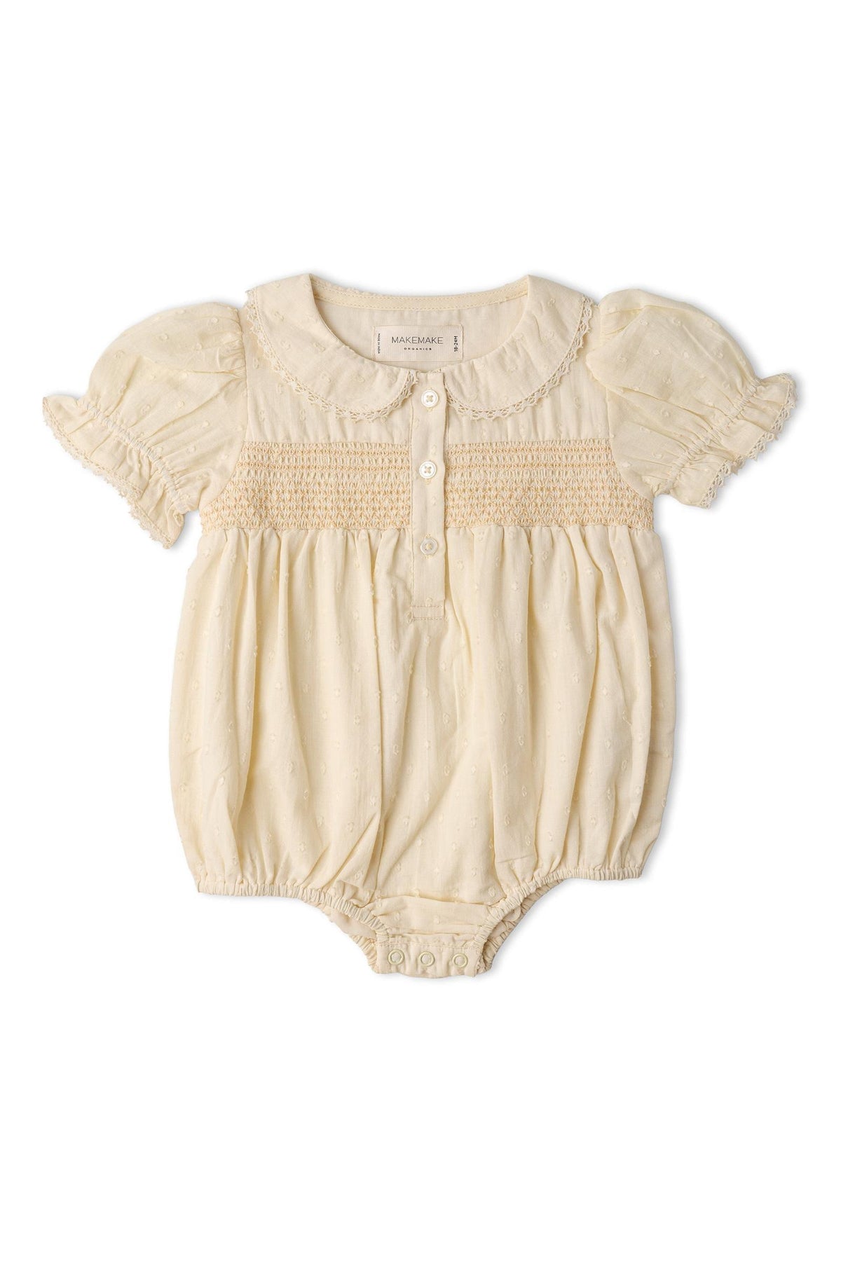 A butter yellow organic cotton romper features a smocked bodice, puff sleeves, and classic wooden buttons. This airy, soft piece is perfect for warm days and playful adventures.