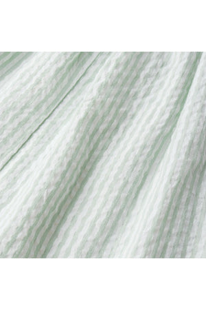 Close-up of a soft, lightweight fabric featuring a light green and white striped pattern. The textured material suggests a breathable, organic cotton ideal for warm-weather comfort.