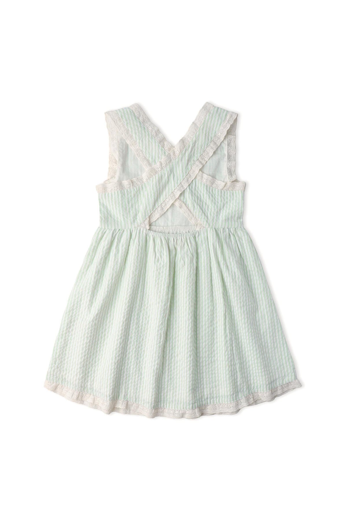 Light green seersucker dress featuring criss-cross straps and a gathered skirt. This organic cotton dress from Makemake Organics is perfect for warm-weather play and stylish summer outings.