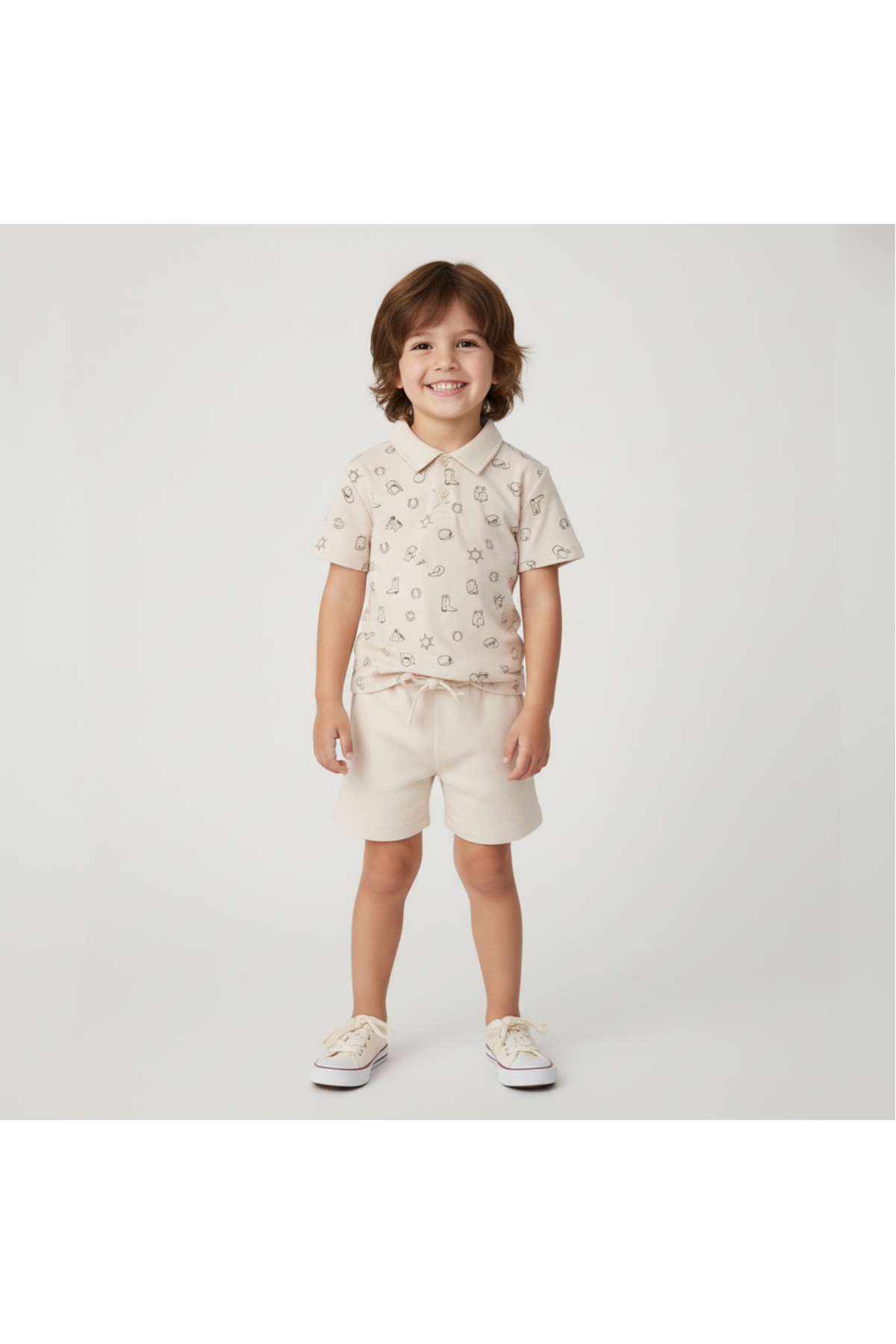 A smiling child wears a beige organic cotton Collar Tee and matching shorts, featuring playful rodeo prints. The outfit is perfect for sunny day adventures and promotes sustainable fashion.