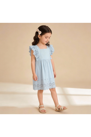 A young girl stands in a light blue organic cotton dress with delicate flutter sleeves and embroidered eyelet details. The soft fabric is perfect for comfortable, stylish playdates.