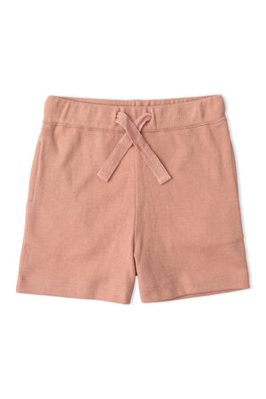 Soft, organic cotton shorts in a blush pink hue with a drawstring waist, perfect for children’s casual wear. Ideal for comfort and playful activities, promoting sustainable fashion choices.