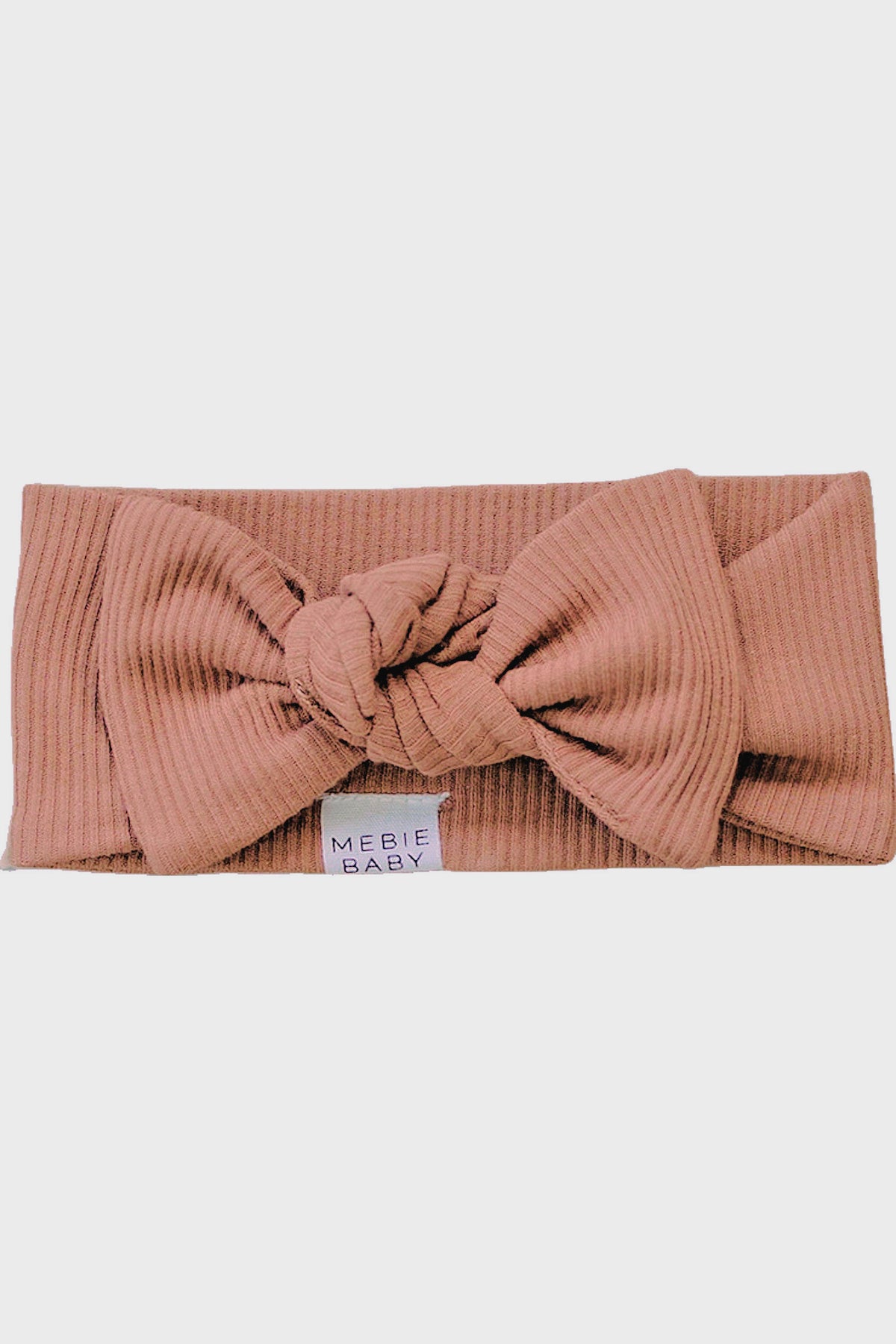 Dusty rose ribbed head wrap with a square knot and Mebie Baby label, made of organic cotton.