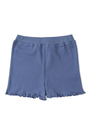 A pair of soft, organic cotton shorts in a muted blue color features a ruffled hem. These comfortable shorts are perfect for casual wear during warm days.