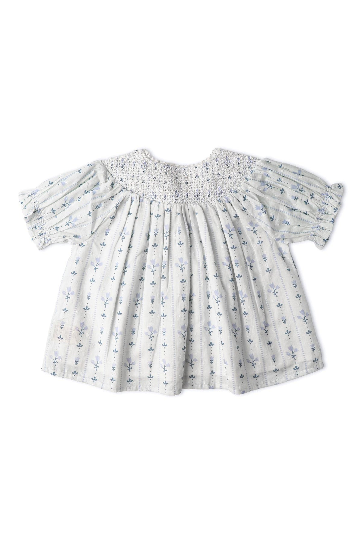 A light blue organic cotton smocked top features delicate floral embroidery and short puff sleeves. The airy design is suitable for sunny day outings, offering both comfort and style.