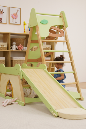 A wooden jungle gym with a slide and climbing ladder in soft green and natural wood tones.