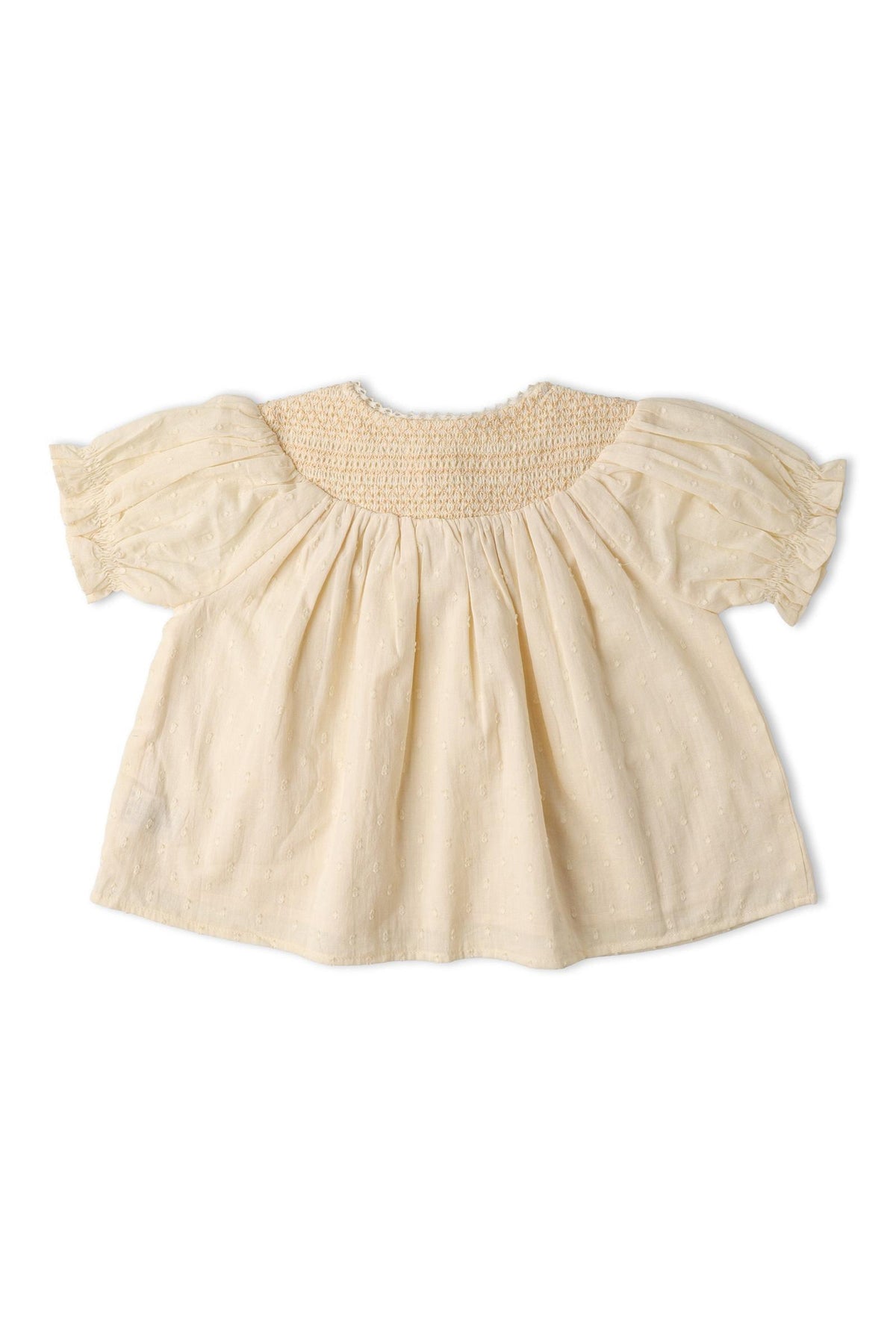 A soft, butter yellow organic cotton smocked top features a textured weave and puffed sleeves. The back showcases delicate smocking, perfect for sunny day outings.