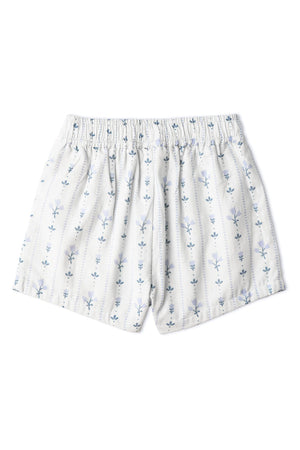 Light blue shorts with a smocked waistband feature a delicate floral pattern. Made from organic cotton, these playful shorts are designed for comfort and sunny day outings.