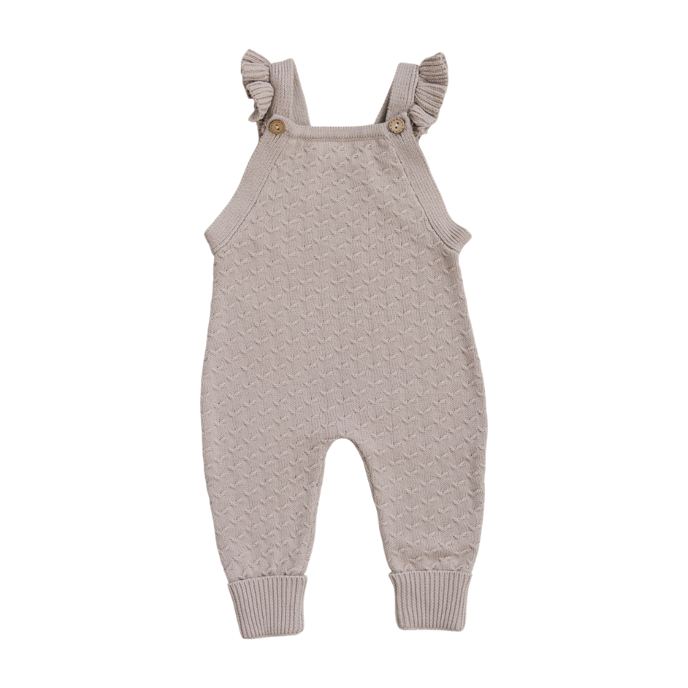 Classic taupe knit overalls for baby girls, featuring delicate ruffle straps and wooden buttons. Made from soft, breathable cotton, these stylish overalls are perfect for everyday wear or special occasions.