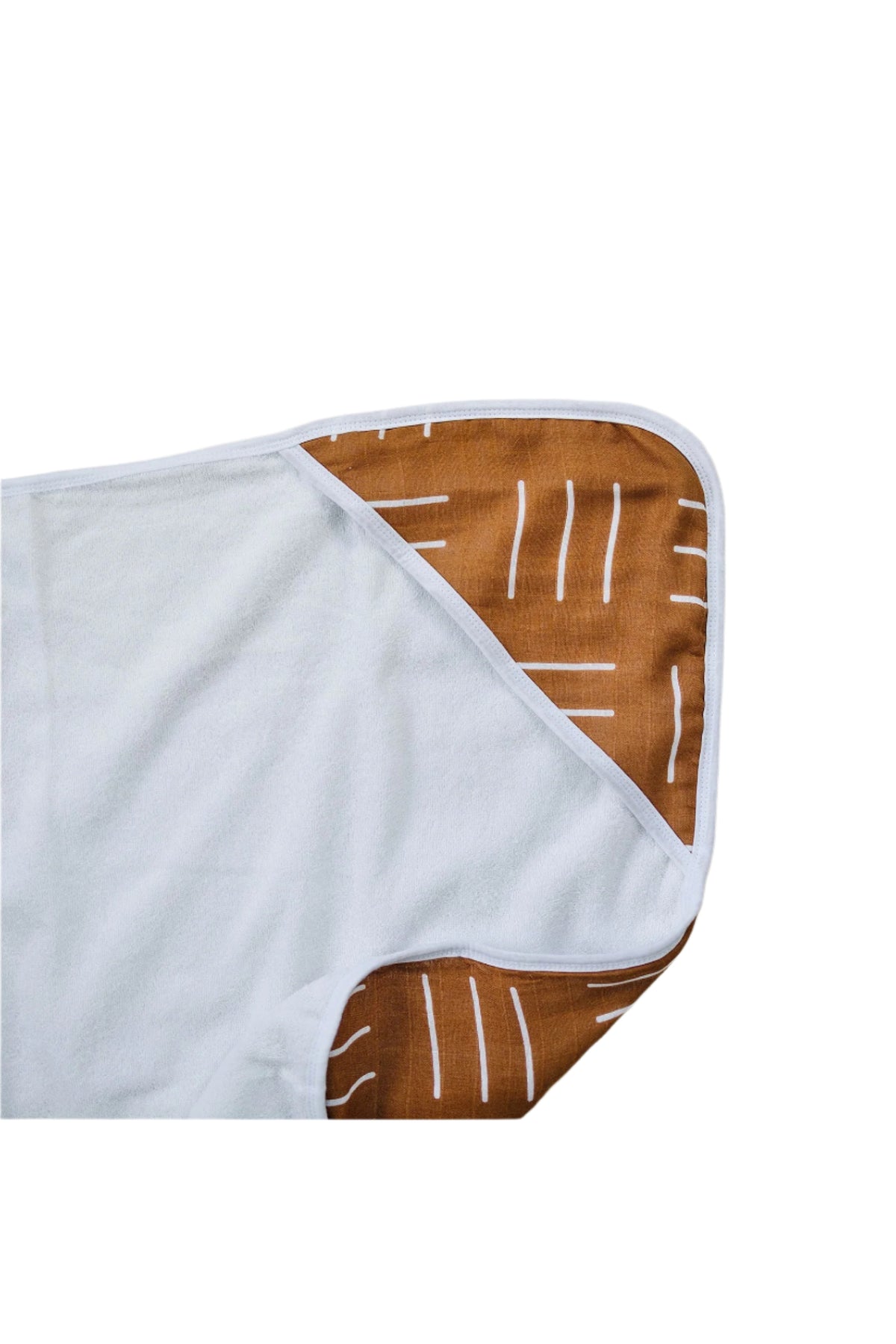 White hooded towel with mustard mudcloth pattern on the hood, featuring white stripes. Made from 100% cotton.