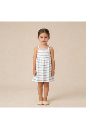 A young girl stands wearing a sleeveless, organic cotton dress featuring light gray and white stripes. The dress has adjustable tie-back straps and a flared skirt, perfect for warm weather.